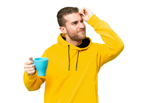 Young handsome blonde man holding cup of coffee over isolated background having doubts and with confuse face expression