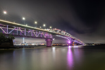Auckland Harbour Bridge glowing in purple. Auckland, New Zealand