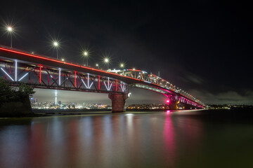 Auckland Harbour Bridge glowing in red. Auckland, New Zealand
