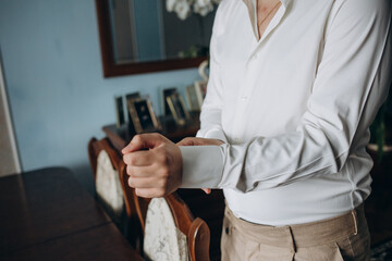 handsome business man buttoning up his shirt sleeves, long hair isolation on background