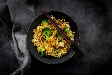 Studio shot of plate of ready-to-eat vegan noodles with broccoli, tofu and soy sauce