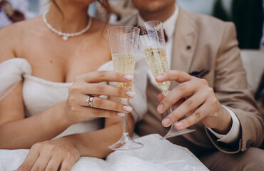 Bride and groom are holding champagne glasses