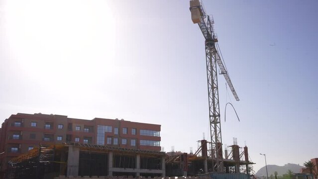 Construction crane in Morocco turning around carrying iron