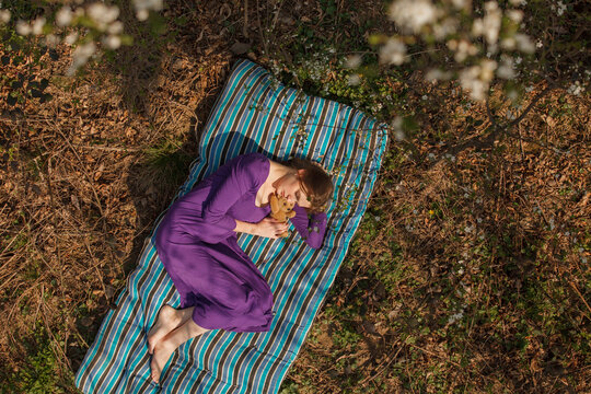 Young woman with stuff toy relaxing on mattress