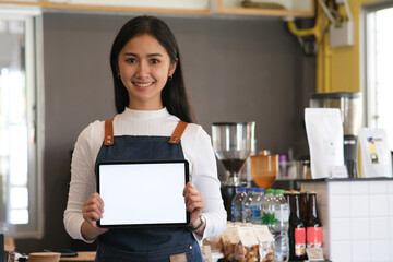 Small business owener holding blank screen of tablet.