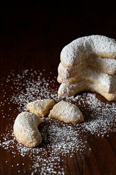 stack of crescent cookies on dark wooden surface