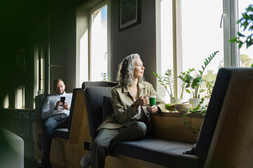 Businesswoman taking a break in office sitting at the window