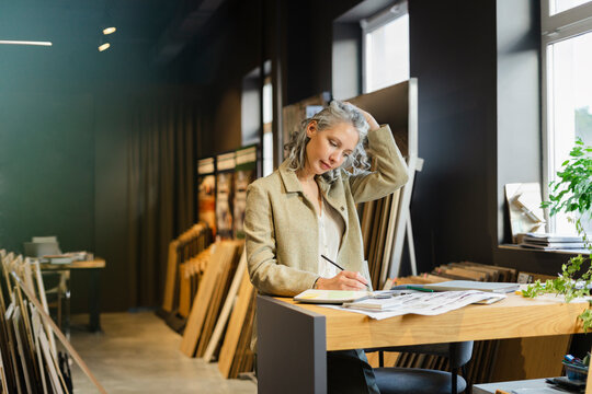 Female Architect Working At Table In Office