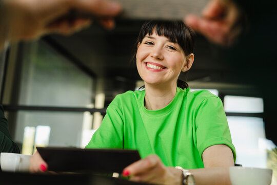 Smiling woman wearing green t-shirt in office