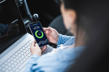 Woman with laptop examining electric car charging app