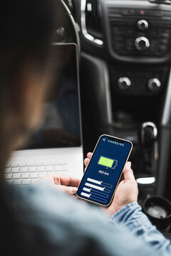 Woman Using Electric Car Charging App On Mobile Phone