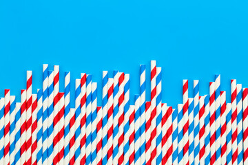 Drinking straws for party on blue background with copy space.