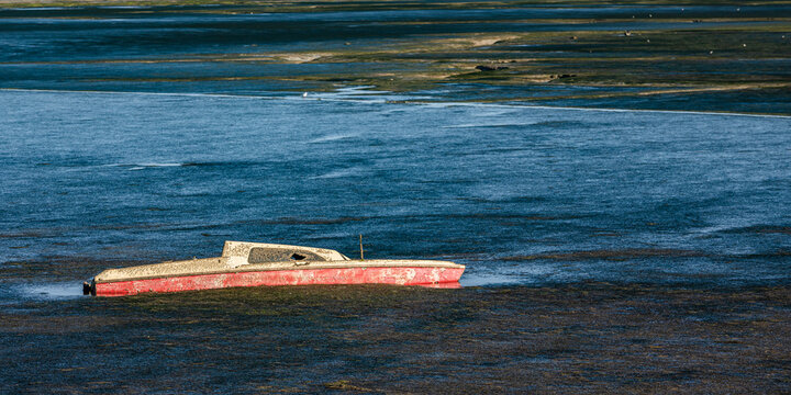 France, Nouvelle-Aquitaine, Loix, Fishing boat abandoned on seashore