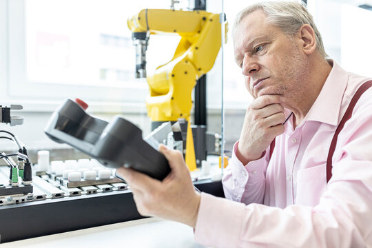 Senior engineer training robot arm with digital control