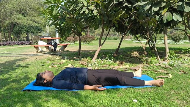 Young Indian woman practicing yoga outdoor in a park. Beautiful girl practice basic yoga pose. Calmness and relax, female happiness. Basic Yoga poses outdoor