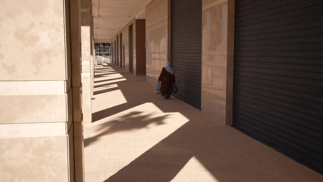 Arabic old woman walking down a Moroccan street