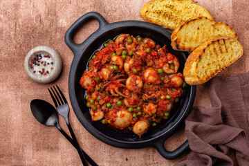Italian stew cuttlefish  with green peas and tomatoes or seppie con piselli in umido. Toasted bread. - obrazy, fototapety, plakaty