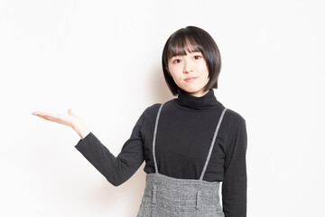 案内のジェスチャーをする若い女性