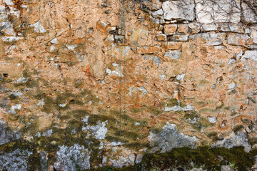 Old ruined stone wall with moss as grunge background