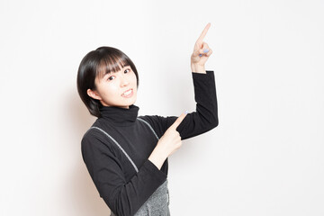 指でポイントを指し示す若い女性