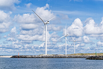 Wind turbines on the shore against cloudy sky in Hvide Sande, Denmark - 568702281