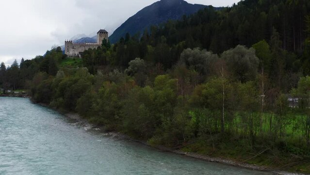 Aerial Ascending Through Trees Beside River Isel With View Of Castle Bruck In Austria