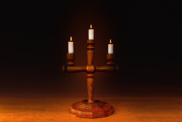Candlestick,Candle flames on a wooden table dark background, symbol of prayer and remembrance.Religion concept.