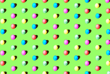 Colored Easter eggs in blue, pink, yellow and green on a pastel background as a pattern. Easter minimal concept. Flat lay.