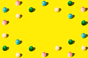 Colored Easter eggs in blue, pink, yellow and green on a pastel background as a pattern. Easter minimal concept. Flat lay.