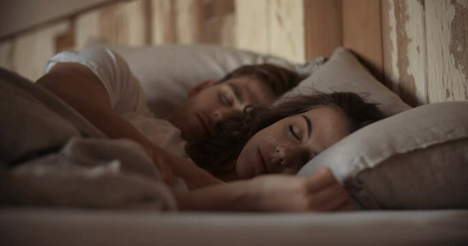 Young sleeping couple in bed