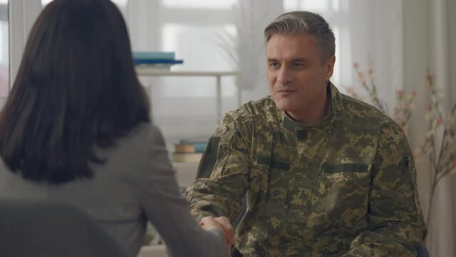 Handshake of happy serviceman and female psychologist, mental health therapy