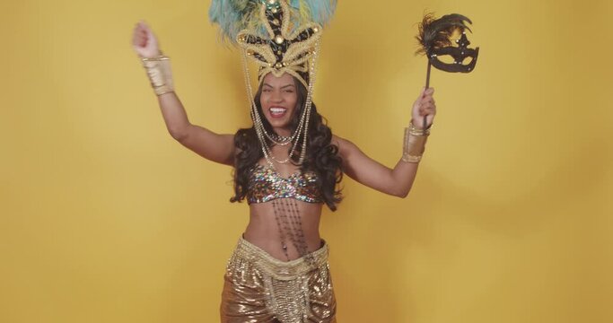 Beautiful black Brazilian woman, dressed in carnival clothes, dancing. with carnival mask in hand.
