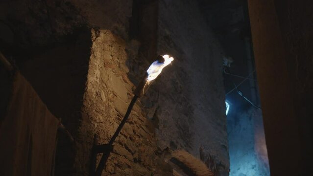 Flame torch light on the wall of street of a medieval city in the night
