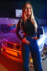 Fototapeta na wymiar Young hipster girl near old sport car at night city