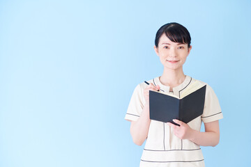 手帳を書くエステ・美容クリニックの女性