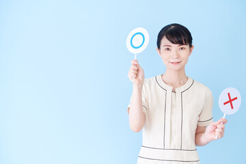 マルバツの棒を持つエステ・美容クリニックの女性