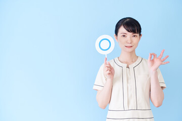 マルバツの棒を持つエステ・美容クリニックの女性