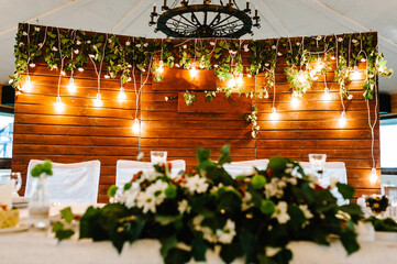 Festive table, arch, stands decorated with composition flowers and greenery in the banquet hall. Table newlyweds in the banquet area on wedding party.