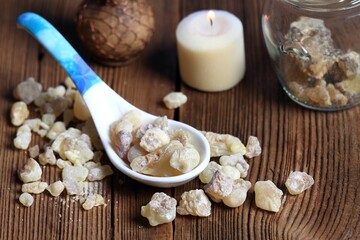 Fototapeta na wymiar Aromatic resin from Boswellia sacra tree in a spoon. High quality frankincense resin from Oman is used for used for religious rites, perfumes and healing effects.