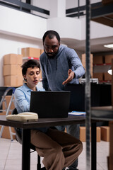 Storehouse employees analyzing package shipping checklist searching for metallic box order while working in warehouse. Diverse team analyzing delivery logistics, planning new transportation service