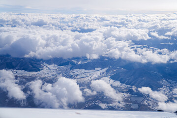 Fototapeta premium the ridge of the Fagaras mountains seen from the plane through the clouds.