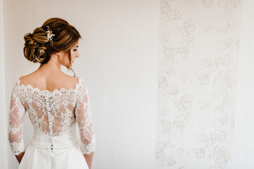 Portrait of a beautiful stylish bride with an elegant hairstyle view from the back. Wedding,...