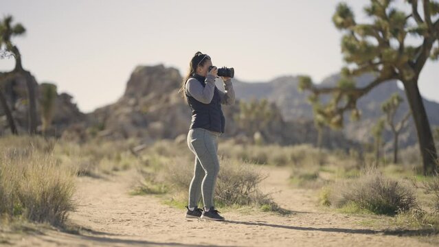 Girl Photographing Joshua Tree National Park desert California with a Sony A1 camera - wide shot of girl in landscape