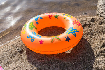 Obraz premium There is an orange inflatable swimming circle on the beach.