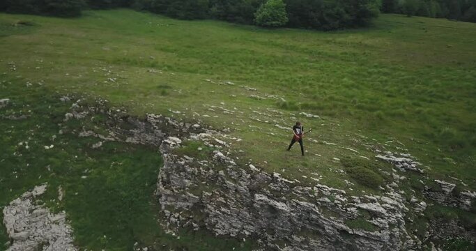 Aerial, a man is playing electric guitar on a small cliff, a rocker fr