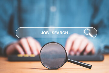 Businessman typing to computer keyboard with magnifier glass and virtual search icon bar for...