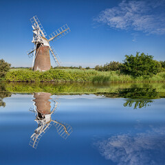 Turf Fen Windmill reflected in the smooth waters of the Norfolk Broads, Norfolk, England