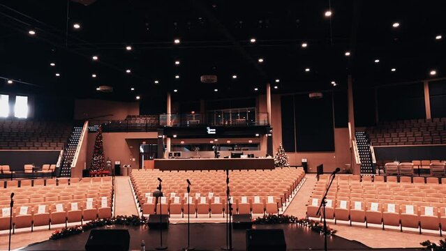 point of view of an artist on the stage on a empty venue. Many microphones. Yellow Box church in Naperville illinois, USA. Wide shot.