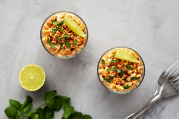 Homemade Mexican Corn Elote Esquites in Cups, top view. Flat lay, overhead, from above.