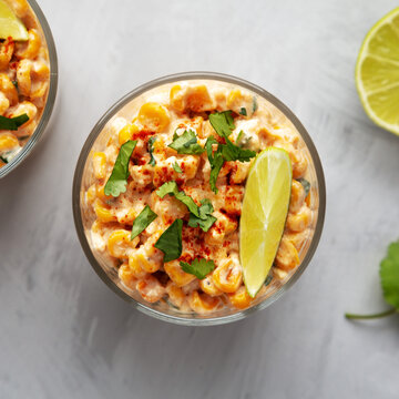 Homemade Mexican Corn Elote Esquites in Cups, top view. Flat lay, overhead, from above. Close-up.